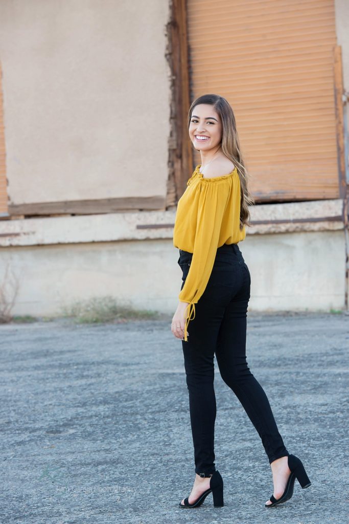 senior girl in mustard shirt and black jeans